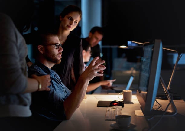 Workers huddled around a computer.