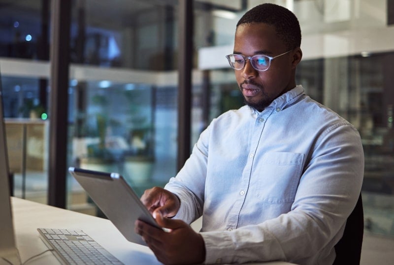a man at his desk working on a tablet