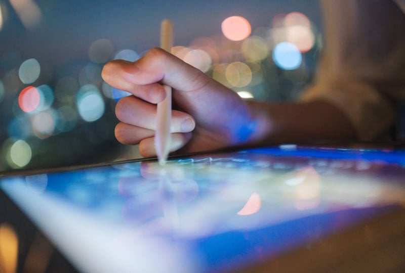 A person using a stylus on a tablet