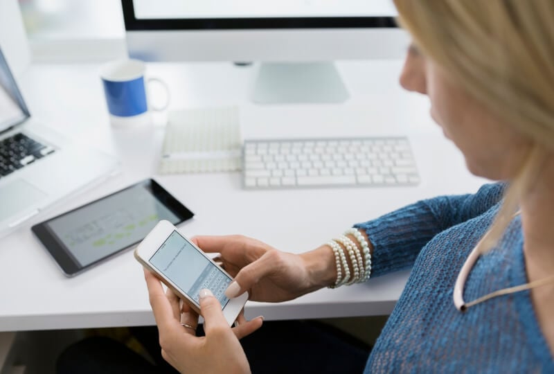 a woman at her desk looking at her phone