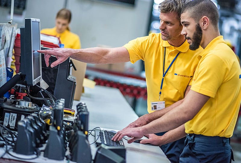 Two workers managing devices
